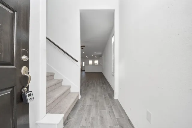 a view of a hallway with wooden floor and staircase