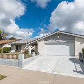 a front view of a house with a yard and potted plants
