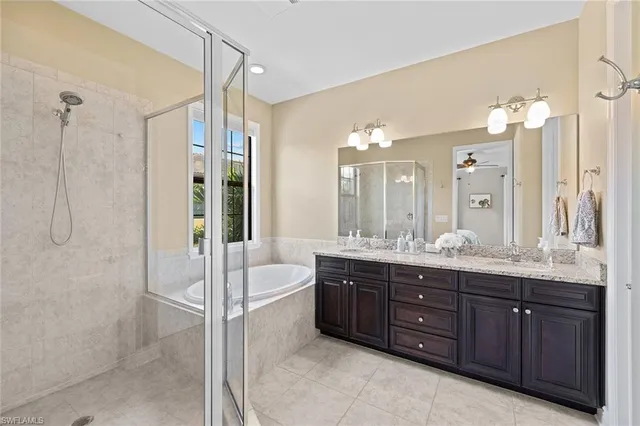 a bathroom with a tub a double vanity sink and mirror
