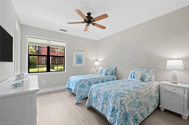 a bedroom with two beds and a large window