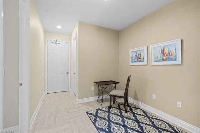 a view of a room with chairs and wooden floor