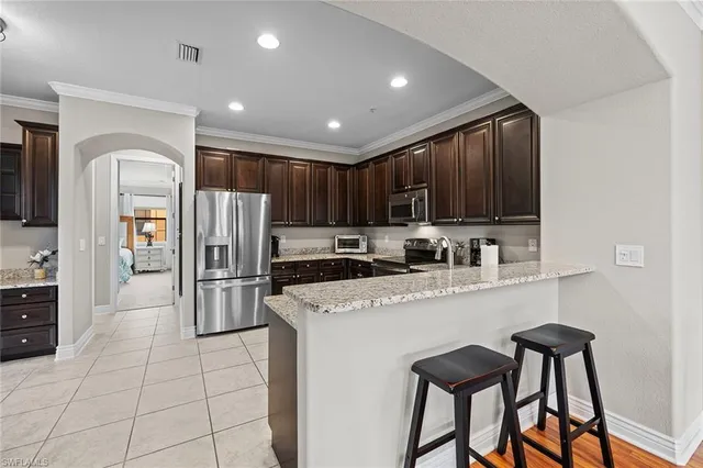 a kitchen with stainless steel appliances granite countertop a refrigerator a stove a sink and a microwave