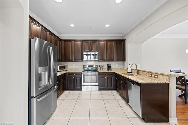 a kitchen with stainless steel appliances granite countertop a refrigerator stove and sink