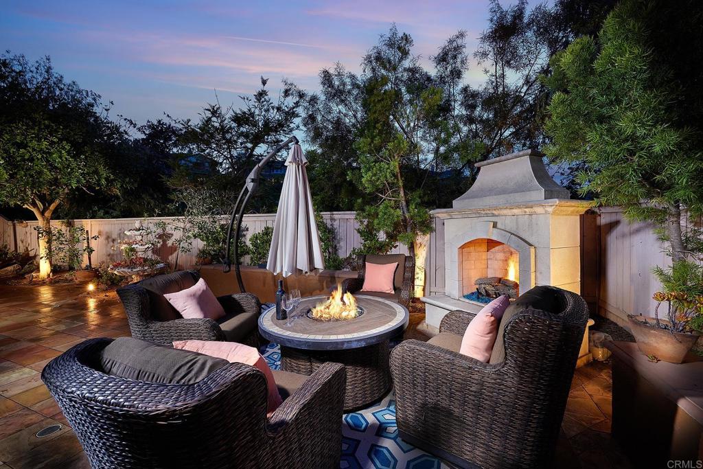 962 Baylor Drive San Marcos, CA 92078 - Photo 37 of 40 a view of a patio with couches table and chairs under an umbrella with a fire pit