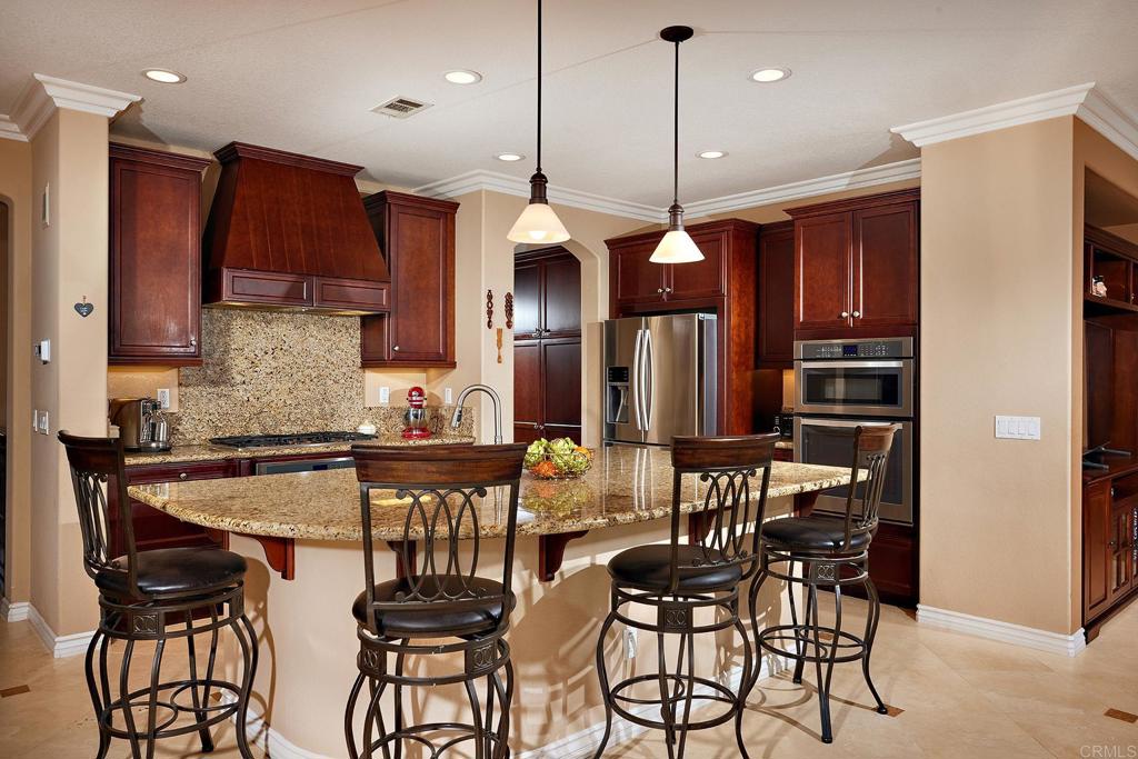 962 Baylor Drive San Marcos, CA 92078 - Photo 8 of 40 a kitchen with stainless steel appliances granite countertop a kitchen island a stove and a refrigerator