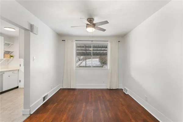 an empty room with a window and wooden floor