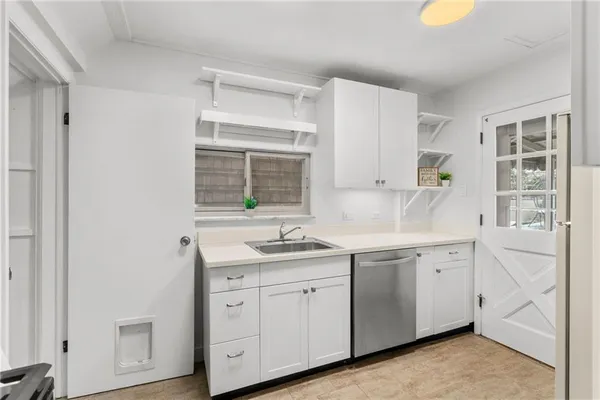 a kitchen with a sink a refrigerator and cabinets