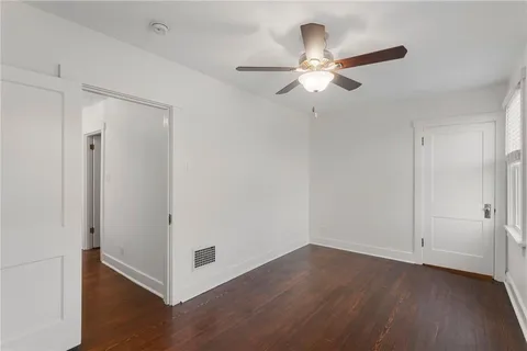 an empty room with a window and wooden floor