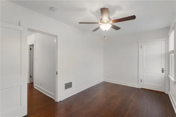 an empty room with a window and wooden floor
