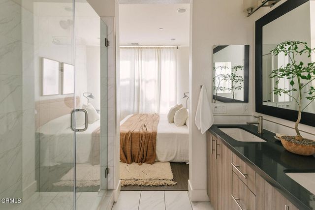 a bathroom with a granite countertop tub sink and glass door