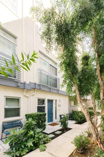 a front view of a house with a yard and potted plants
