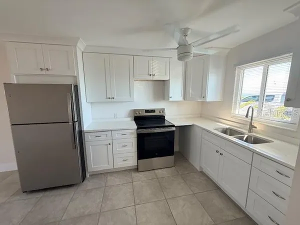 a kitchen with a refrigerator sink and cabinets