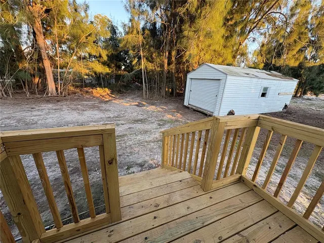 a view of a house with backyard and wooden deck