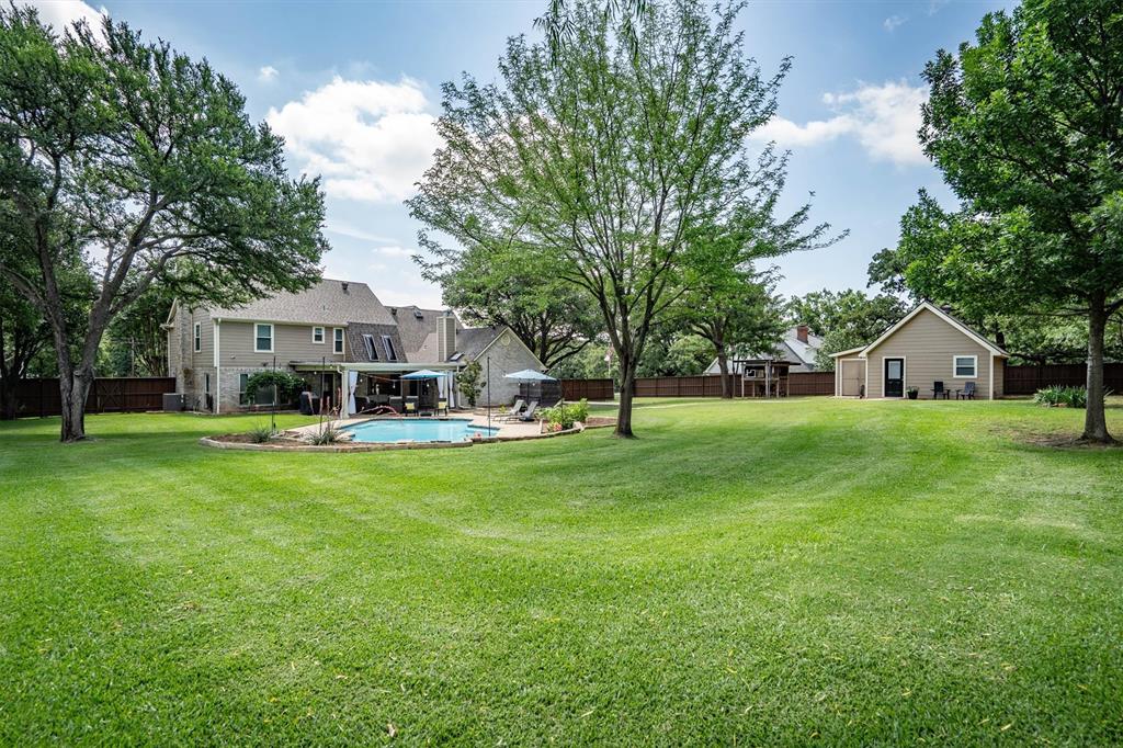 410 Simmons Road Double Oak, TX 75077 - Photo 36 of 40 Expansive backyard with mature trees and lush lawn; private and room to roam.