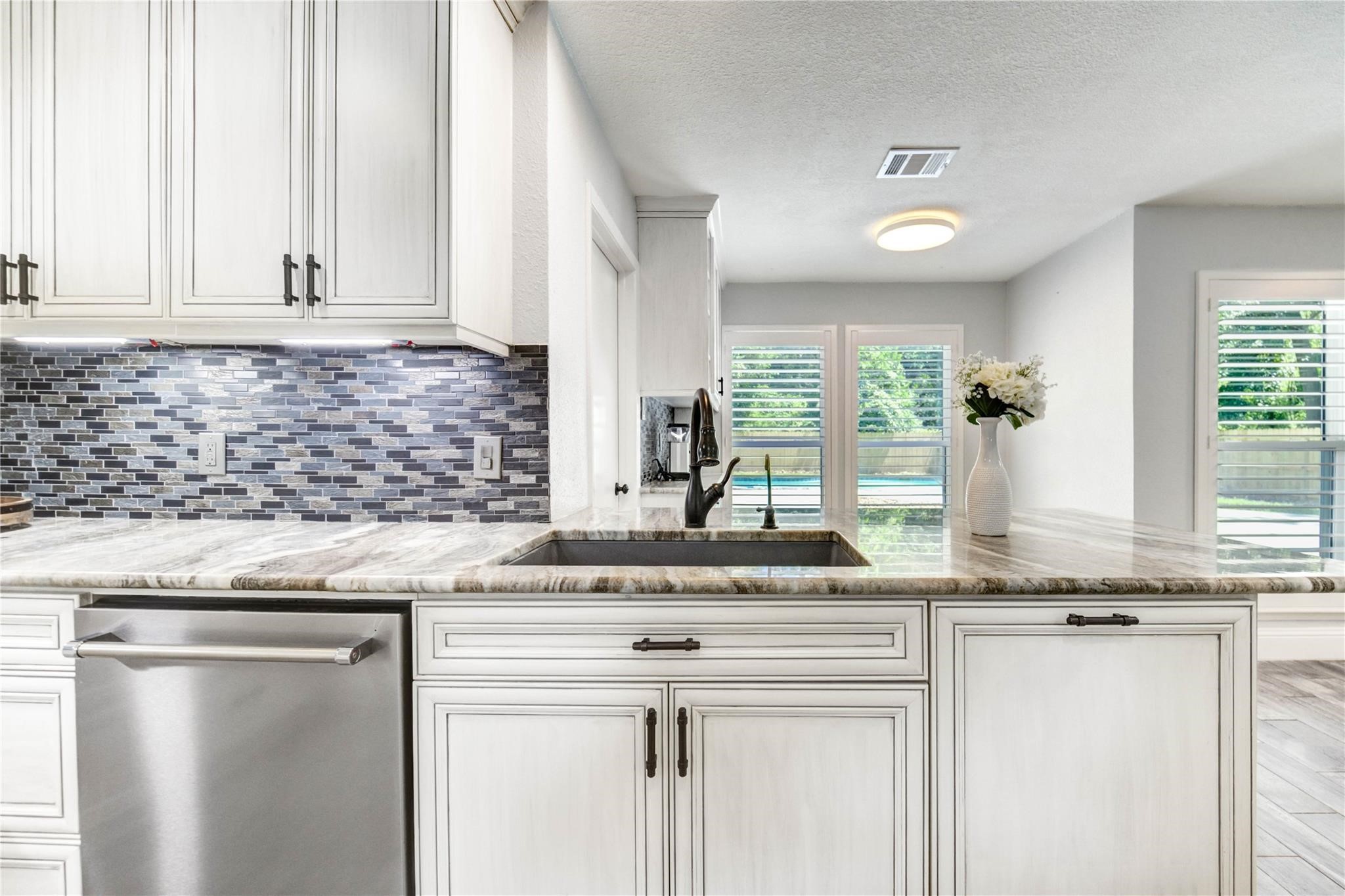 1904 Nursery Road The Woodlands, TX 77380 - Photo 12 of 43 a kitchen with granite countertop white cabinets and a window