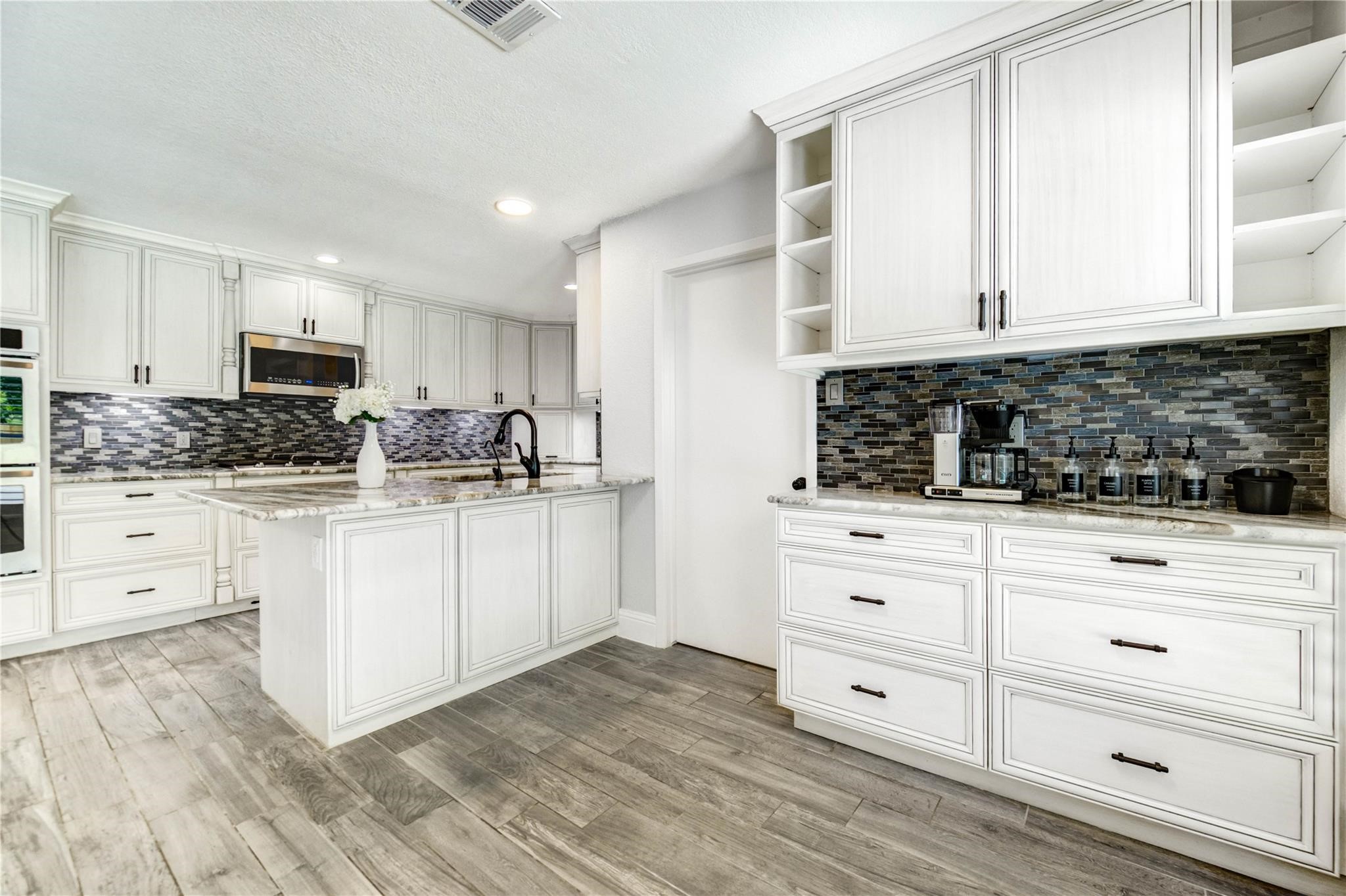 1904 Nursery Road The Woodlands, TX 77380 - Photo 13 of 43 a kitchen with stainless steel appliances white cabinets and a sink