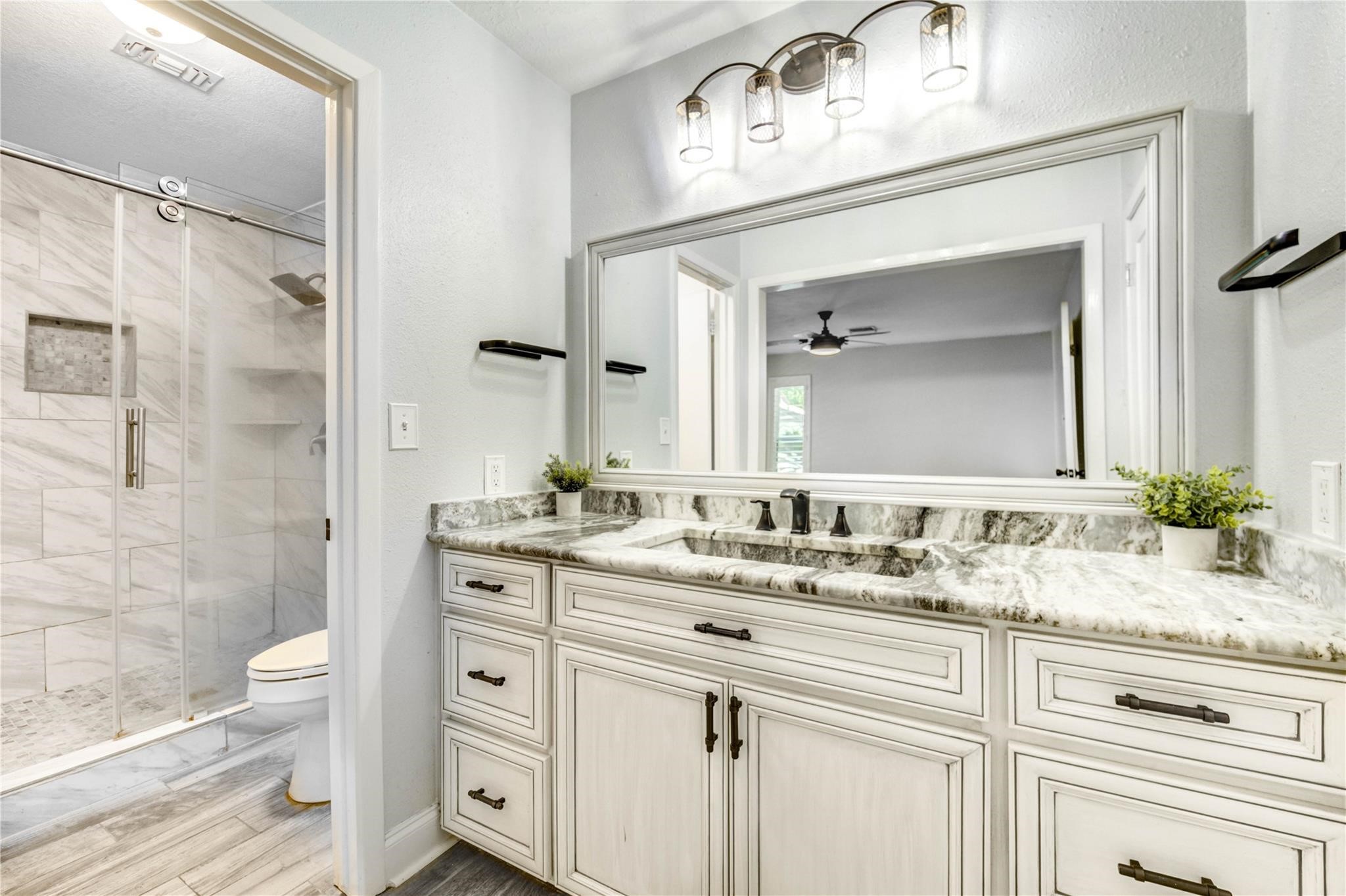 1904 Nursery Road The Woodlands, TX 77380 - Photo 21 of 43 a bathroom with a granite countertop sink vanity mirror and shower