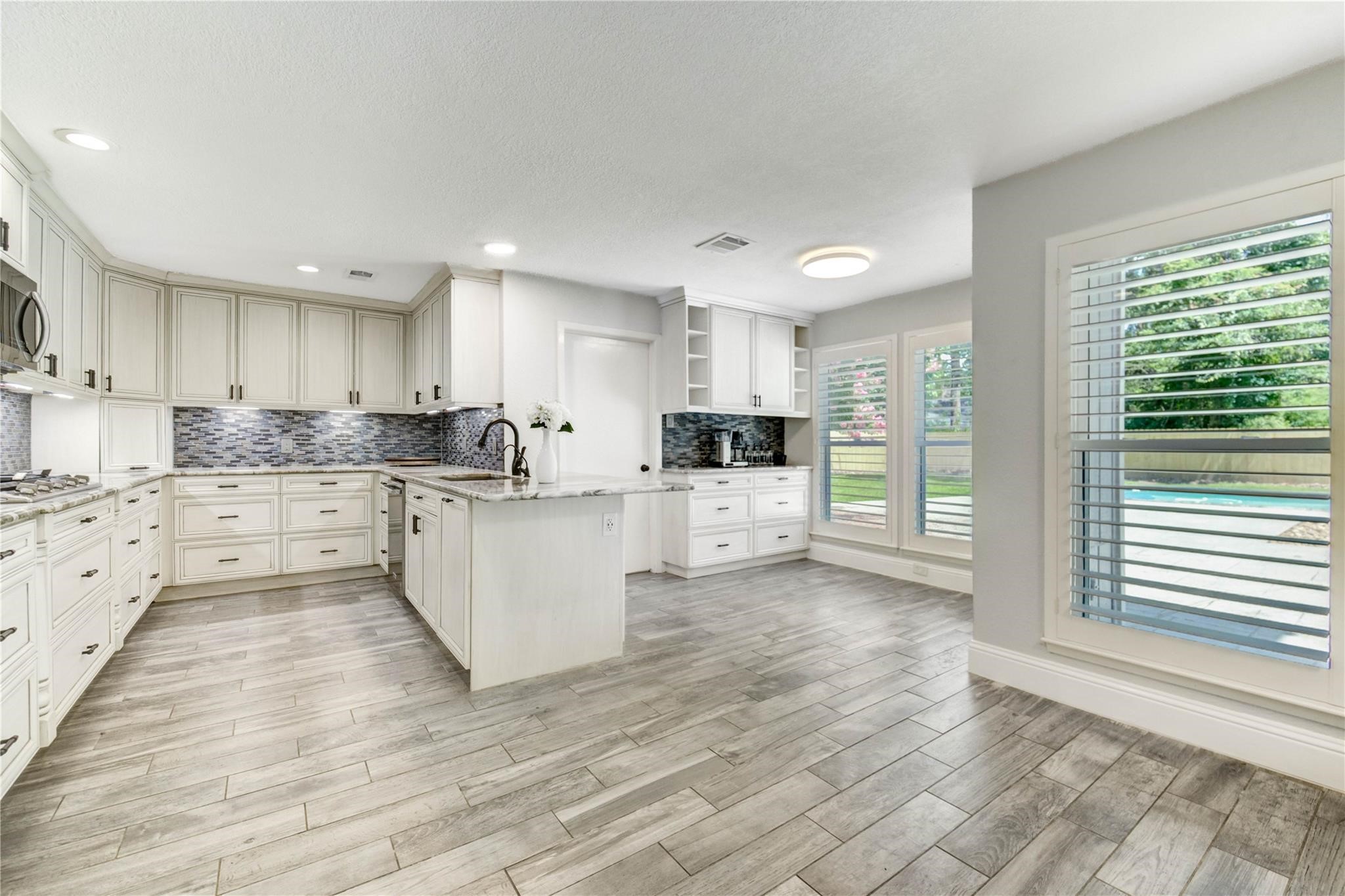 1904 Nursery Road The Woodlands, TX 77380 - Photo 8 of 43 a large kitchen with cabinets and stainless steel appliances