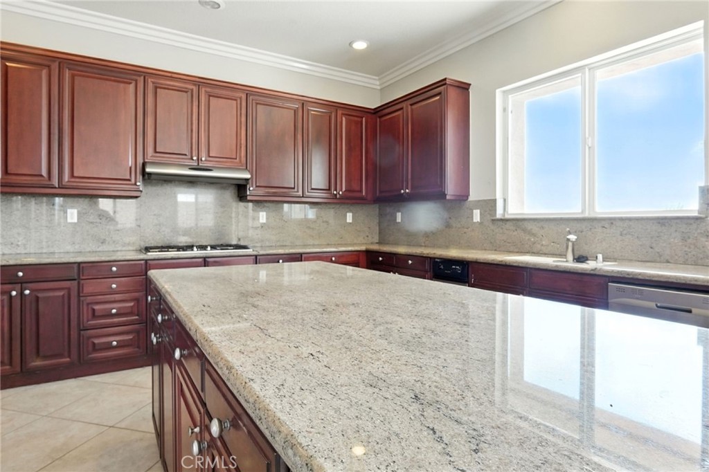 18338 Lakepointe Drive Riverside, CA 92503 - Photo 18 of 40 a kitchen with granite countertop a sink a stove and cabinets