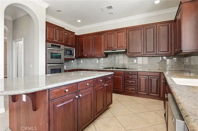 a kitchen with stainless steel appliances granite countertop a stove sink and cabinets