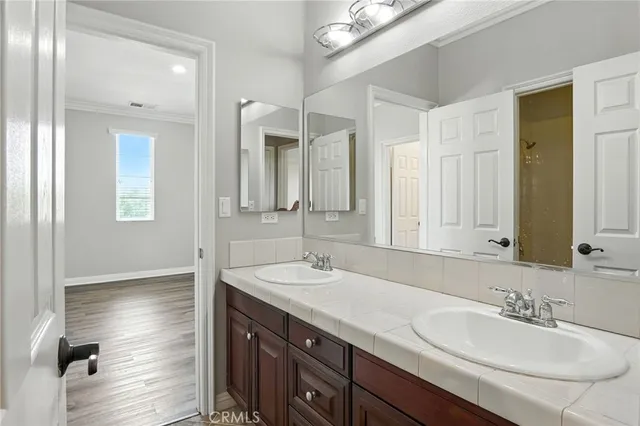 a bathroom with double vanity sinks and a mirror