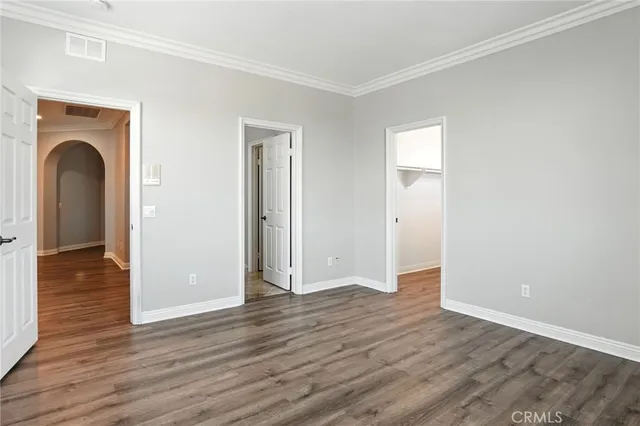 an empty room with wooden floor and closet