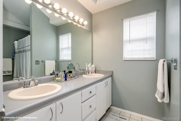 a bathroom with a double vanity sink a mirror and a shower
