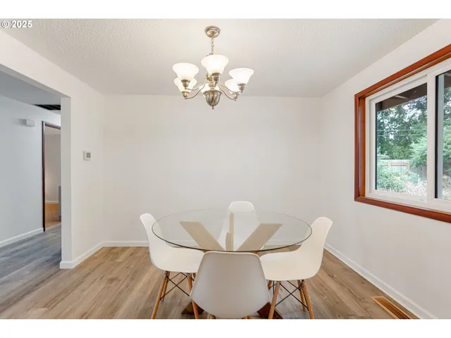 a view of a dining room with furniture a chandelier and wooden floor