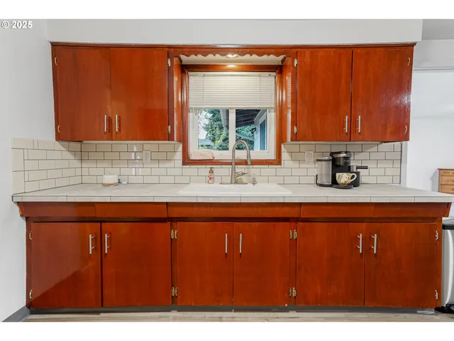 a kitchen with a sink a window and cabinets