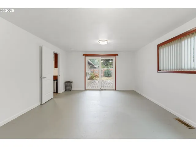a view of a big room with windows and chandelier fan