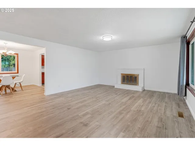 a view of a livingroom with wooden floor and furniture