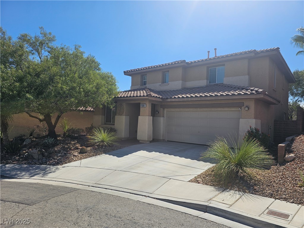 Mediterranean / spanish home featuring concrete driveway, stucco siding, an attached garage, and a tiled roof