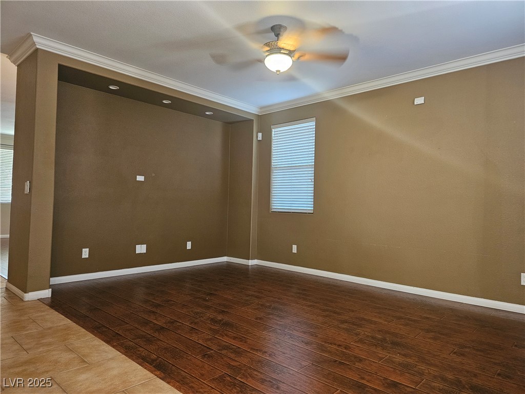 11081 Village Ridge Lane Las Vegas, NV 89135 - Photo 12 of 14 Unfurnished room with ornamental molding, a ceiling fan, plenty of natural light, and dark wood-style flooring