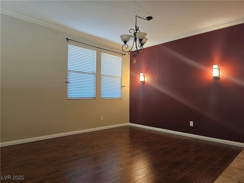 11081 Village Ridge Lane Las Vegas, NV 89135 - Photo 9 of 14 Spare room with crown molding, a chandelier, and dark wood finished floors