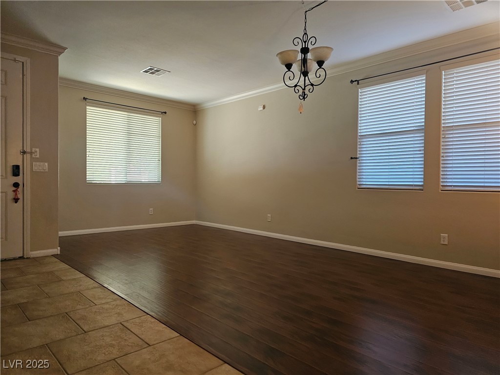 11081 Village Ridge Lane Las Vegas, NV 89135 - Photo 10 of 14 Unfurnished room featuring ornamental molding, dark wood finished floors, and a chandelier