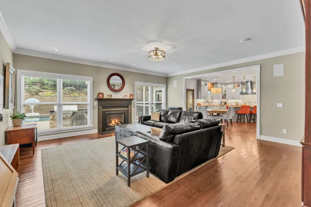 a living room with furniture a fireplace and a floor to ceiling window