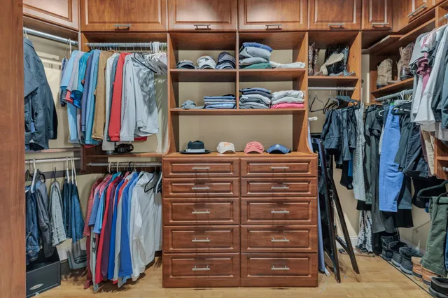 a view of walk in closet with clothes and shoes