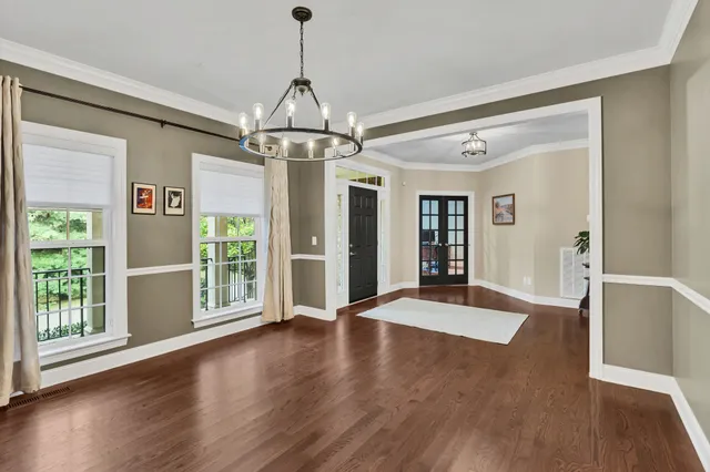a view of a livingroom with wooden floor and a chandelier