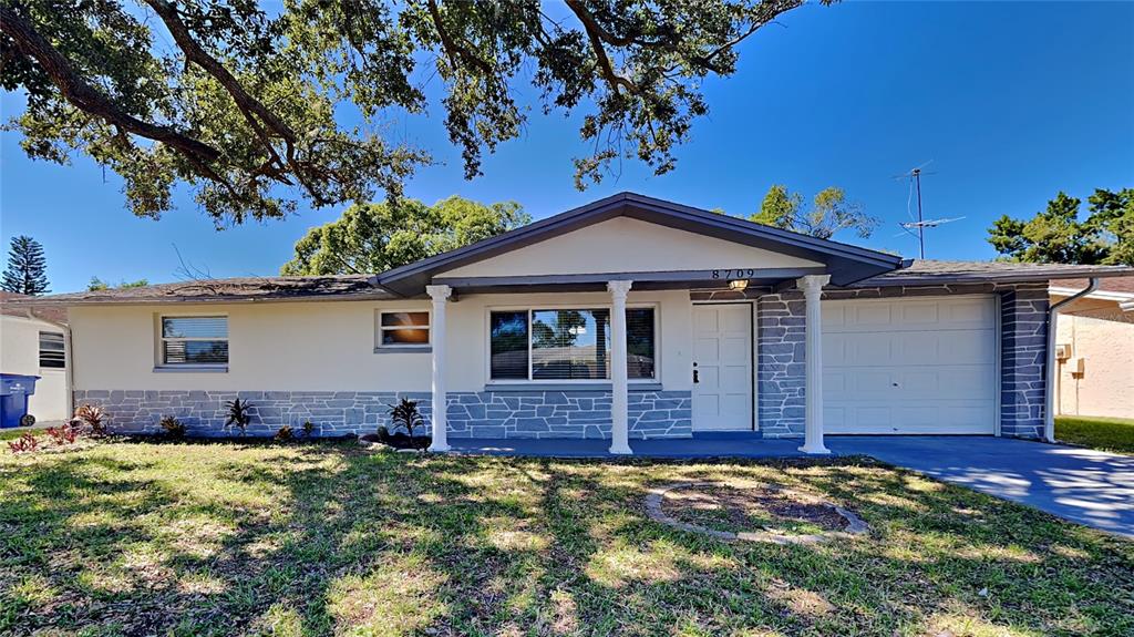 8709 Robilina Road Port Richey, FL 34668 - Photo 1 of 1 a front view of a house with a yard