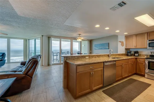a large kitchen with kitchen island granite countertop a large window