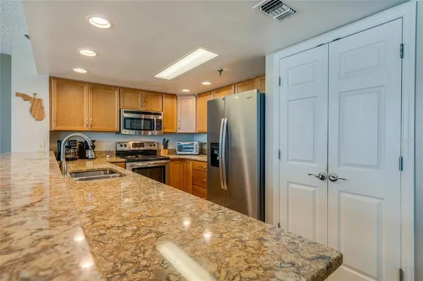 a kitchen with granite countertop a refrigerator and a sink