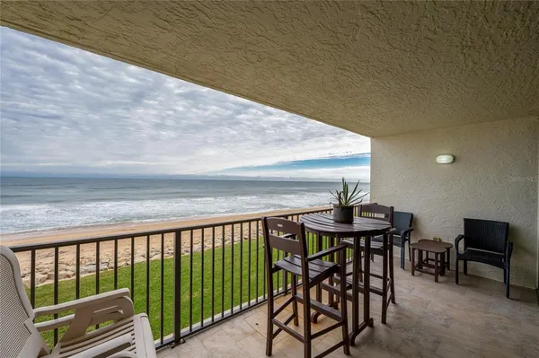 a view of a balcony with furniture and wooden floor