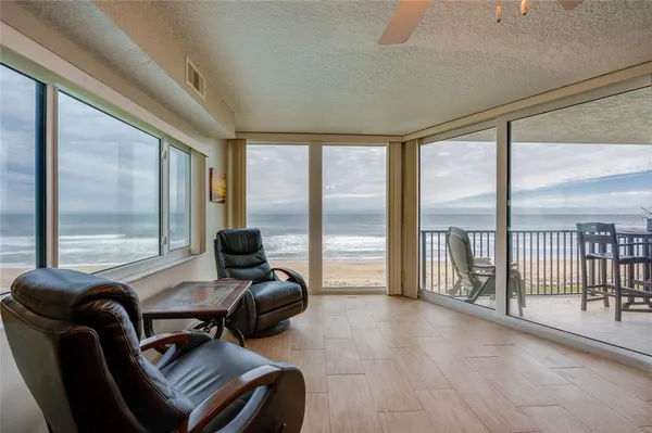 a view of a livingroom with furniture and floor to ceiling window