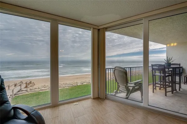 a view of a room with chairs and floor to ceiling window
