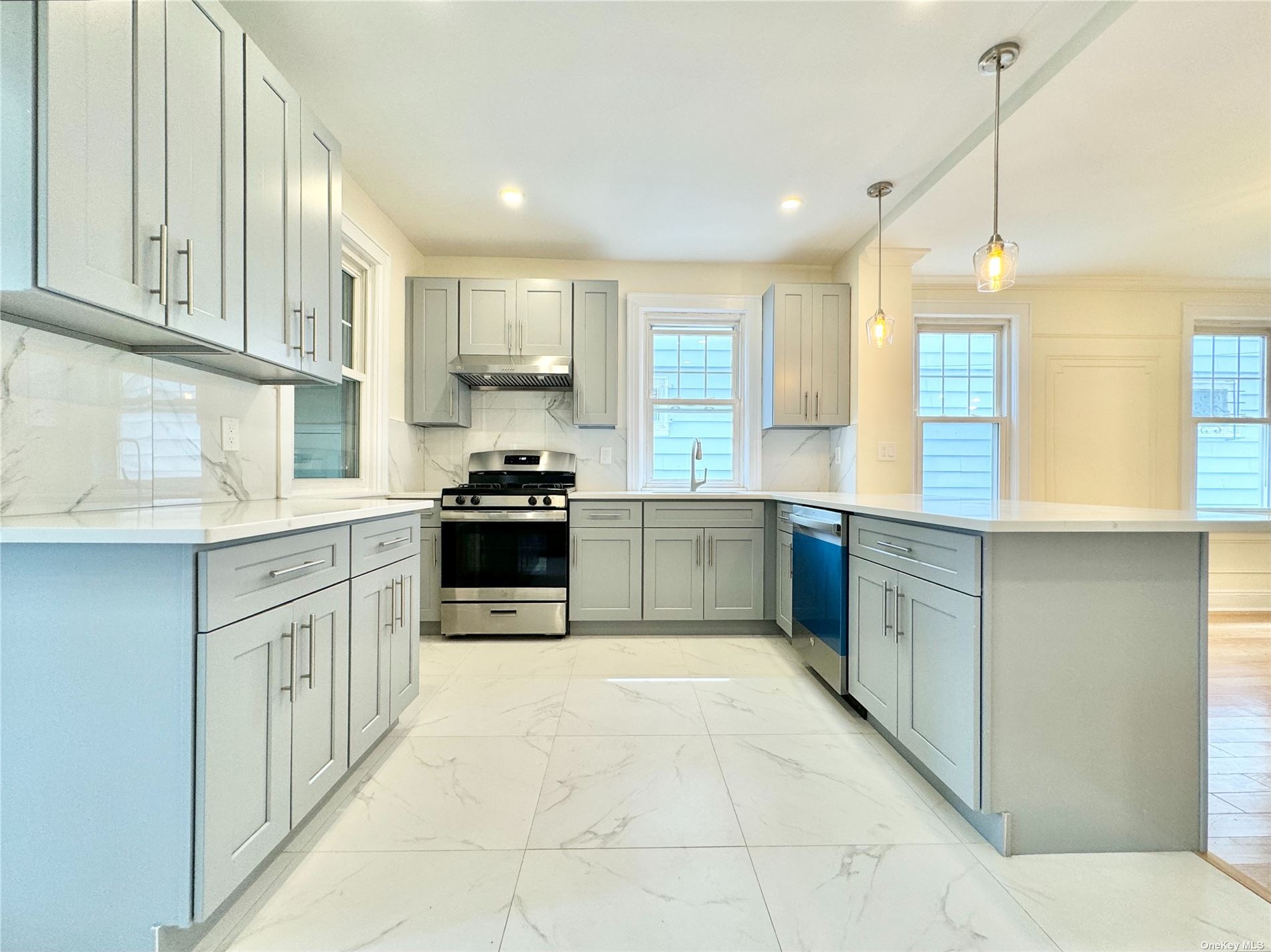 a large kitchen with stainless steel appliances granite countertop a stove a sink and a refrigerator