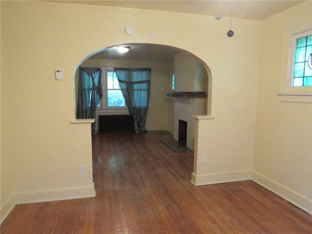 423 Braddock Road Pittsburgh, PA 15221 - Photo 7 of 36 an empty room with wooden floor cabinet and windows