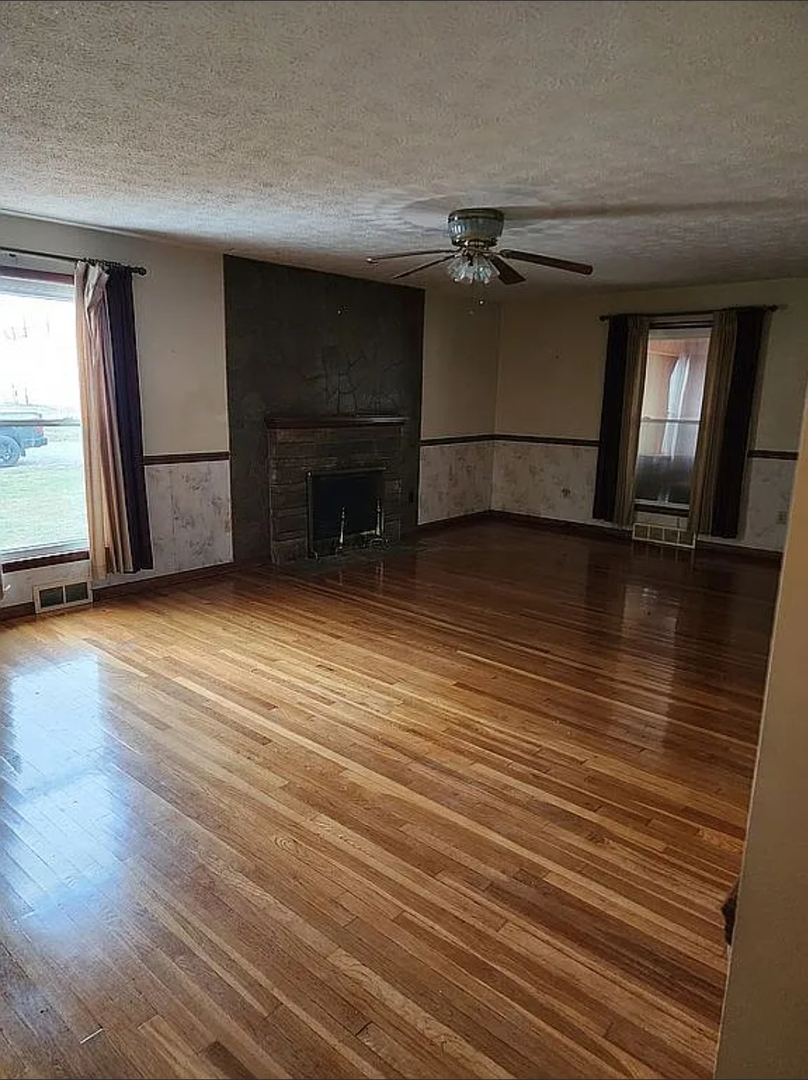 1100 John Stelle Road McLeansboro, IL 62859 - Photo 14 of 20 an empty room with wooden floor and a fireplace