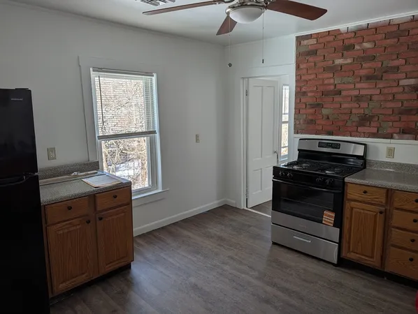 a kitchen with a stove and wooden floor