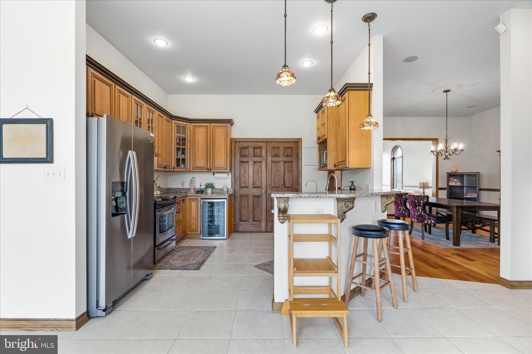 11820 Shimpstown Road Mercersburg, PA 17236 - Photo 15 of 75 a kitchen with stainless steel appliances granite countertop a refrigerator a oven a sink a dining table and chairs with white cabinets