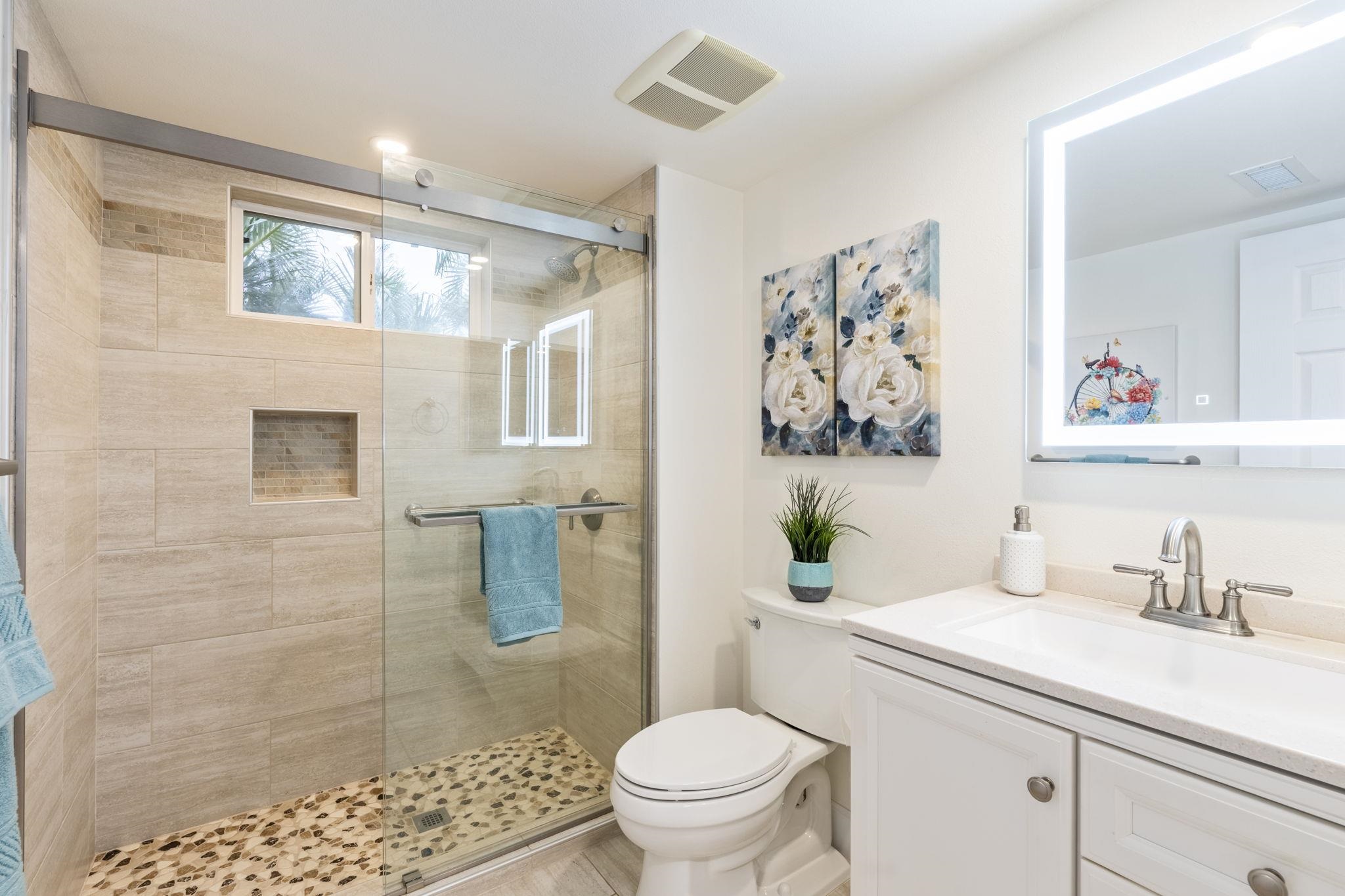 16 Kai Makani Loop, Unit D201 Kihei, HI 96753 - Photo 27 of 50 a bathroom with a sink a toilet a mirror and shower